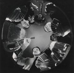 a group of people sitting around a table with cards