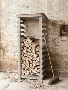 a stack of logs sitting in front of a brick wall next to a wooden ladder