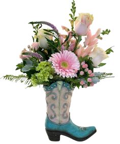 a cowboy boot filled with pink flowers and greenery next to a planter on a white background