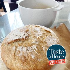 a loaf of bread sitting on top of a table next to a cup of coffee