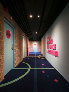 an empty hallway with blue carpet and red letters on the wall, along with a yellow door