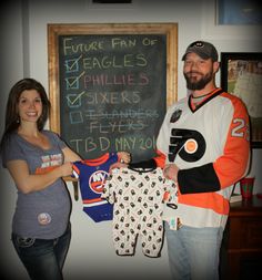 a man and woman holding jerseys in front of a chalkboard