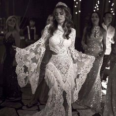 a woman in a white dress standing next to other women