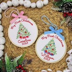 two cross stitch christmas ornaments on a basket