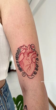 a woman's arm with a heart tattoo on it