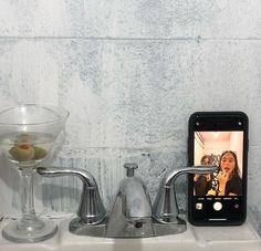 a bathroom sink with an appliance next to it and a wine glass on the counter