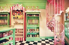 an old fashioned candy shop with green walls and pink shelves, checkered flooring