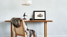 a wooden table topped with a chair next to a framed photo and an animal statue