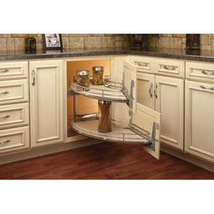 a corner shelf in the middle of a kitchen with drawers and cupboards on both sides