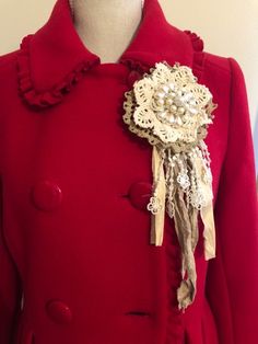 a red coat with a flower brooch on it