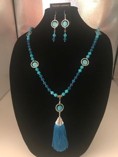 This is the prettiest two tone blue glass bead necklace. It also has a beautiful blue silk tassel pendant that hangs 5 inches. I also added a touch of blue coin beads inside some silver tone rings. All of this together made it just gorgeous. Reminds me of the beautiful blues everyone wears in the summer. I also added a pair of earrings that match perfect. They hang about 3 inches long. Love this piece.  Free gift with every purchase  Anti-tarnish locking bag to store your beautiful jewelry Elegant Blue Necklaces With Dangling Beads, Blue Beaded Necklace With Dangling Czech Glass Beads, Blue Tasseled Jewelry As Gift, Blue Tasseled Jewelry For Gift, Blue Tassel Jewelry Gift, Blue Tassel Jewelry As Gift, Elegant Blue Beaded Necklace With Dangling Beads, Elegant Blue Tassel Necklace Gift, Elegant Blue Tassel Necklace As Gift