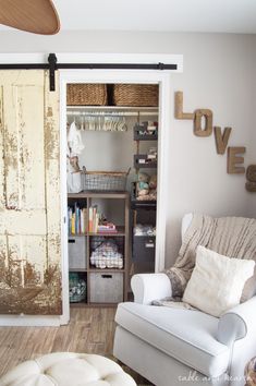 a white chair sitting in front of a closet filled with lots of storage and furniture