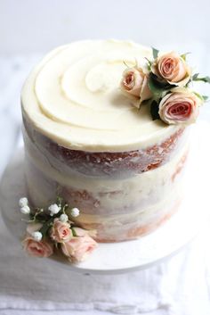 a white cake with frosting and flowers on top