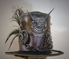 IMPORTANT NEWS!!  Due to the UK leaving the EU, postage prices have increased but have kept them as low as I can for my customers. If you would like to purchase more than one item, please contact me first so I can invoice you with the lowest postage price. Unique, leather mini top hat. Steampunk style. Attaches to the head by 2 alligator clips Approx Size: Brim Width 15.5cm                         Height 10cm Bespoke mini top hats available. One of a kind Details: Leather top hat Metal details Metal buckle Ribbon band Clock parts Metal chain Black feathers Peacock feather Metal spike Tracked and signed postage worldwide available, please contact me before purchasing. Steampunk Top Hat With High Crown For Themed Events, Steampunk High Crown Hat For Themed Events, Steampunk Costume Top Hat, Vintage Top Hat With High Crown For Cosplay, Vintage High Crown Top Hat For Cosplay, Steampunk High Crown Mini Hat For Themed Events, Handmade Vintage High Crown Top Hat, Adjustable Steampunk Top Hat For Themed Events, Steampunk High Crown Top Hat For Cosplay