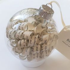 an ornament made out of book pages with a heart shaped tag attached to it