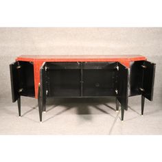 an orange and black sideboard with two doors on the bottom, one door open