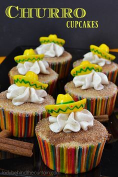 cupcakes with white frosting and colorful toppings on a black platter