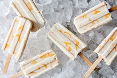 four popsicles sitting on top of ice covered in caramel and white icing