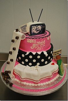 a three tiered cake is decorated with pink and black polka dots, an old tv on top