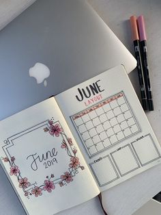 an open planner book sitting on top of a laptop computer next to a pen and pencil