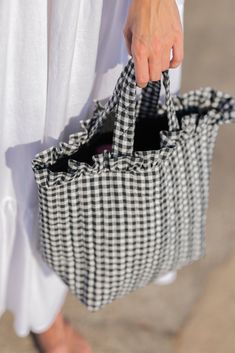 a person holding a black and white checkered bag