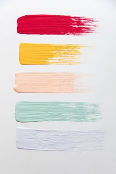 four different colors of paint on a white surface with one red, the other yellow