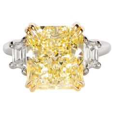 a fancy yellow diamond ring with three baguets