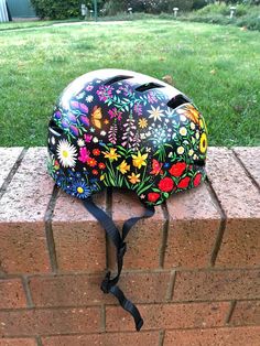 a colorful helmet sitting on top of a brick wall