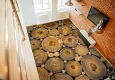 an aerial view of a living room with wood logs on the floor and brick walls