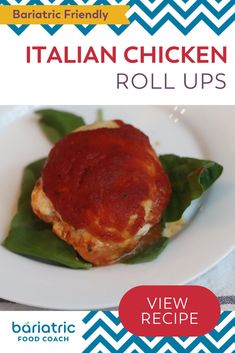 an italian chicken roll ups recipe on a white plate with green leafy leaves and red sauce