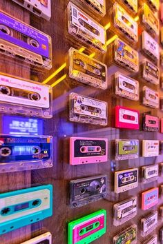 a wall full of old school cassette tapes and tape recorders, all in different colors