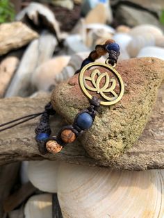 "The lovely and enchanting lotus flower that reminds us to rise up, stay strong and persevere. A thoughtful and loving gift for a friend or loved one facing life challenges or who has risen to the occasion and has fought bravely and courageously. The gorgeous 6mm Sodalite stones are so beautiful paired with the earth toned DZI Agate stones which lend an organic quality to this hand knotted macrame bracelet. The deep dark brown cotton cord really sets off these colors perfectly. The wood beads on Yoga Symbols, Lapis Lazuli Bracelet, Inspirational Bracelets, Loving Gifts, Yoga Bracelet, Macrame Bracelet, Life Challenges, Macrame Bracelets, Flower Bracelet