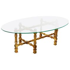 a glass and brass coffee table with four legs