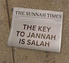 a newspaper laying on the ground next to a street sign that reads, the key to jannah is salah