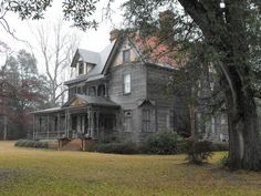 an old house is surrounded by trees and grass