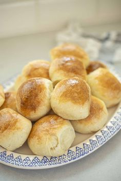 rolls on a blue and white plate sitting on a table