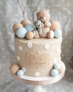 a baby shower cake with a teddy bear on top