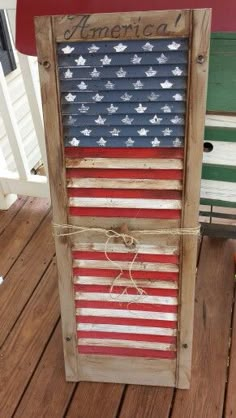 an american flag made out of pallets on a porch with the words america painted on it