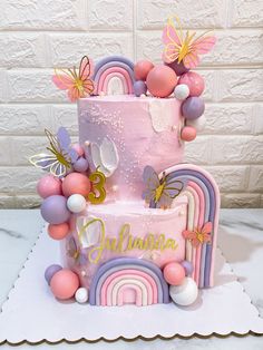 a pink and purple cake with butterflies on top