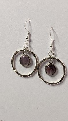 Harness the mystical energy of Super 7 stones with these enchanting earrings. The Super 7, known as a "Melody Stone," combines seven powerful minerals, believed to enhance spiritual growth, psychic abilities, and clarity. Each earring features a beautifully set Super 7 gemstone, dangling gracefully within a silver-tone hammered hoop, adding an elegant yet earthy touch to your look. These lightweight earrings are perfect for everyday wear, making them a go-to accessory for those attuned to spirit Nature Inspired Fashion, Hoop Design, Earrings Crystal, Jewelry Statement, Lightweight Earrings, Light Weight Earrings, Stone Earrings, Salt Lake City, Spiritual Growth