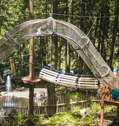 an outdoor play area in the middle of a forest