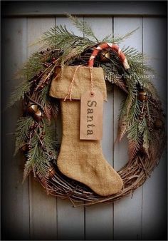 a christmas stocking hanging on the side of a door with pine cones and berries