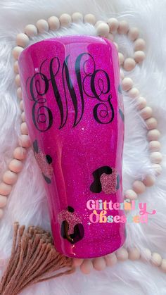 the monogrammed pink tumbler is next to a beaded necklace and beads