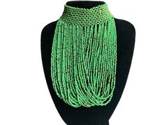 This stunning necklace is a true representation of African craftsmanship and heritage. The intricate design features vibrant green beads expertly strung together to create a beautiful choker pendant. The necklace has an ethnic and regional style and is perfect for women who appreciate unique and handmade jewellery. The necklace is made from high-quality materials that are durable and long-lasting. The beads are carefully selected for their colour and texture, and the pendant is designed to complement the overall aesthetic of the piece.  Neck Dimensions:40cm Drop  Length:20cm Colour: Green Material: Beads Festival Green Jewelry With Round Beads, Traditional Green Beaded Necklace For Festival, Green Beaded Jewelry For Festivals, Traditional Green Necklaces For Festivals, Traditional Green Jewelry With Spacer Beads, Green Round Beads Jewelry For Festival, Green Beads For Jewelry Making And Festivals, Green Round Beaded Jewelry For Festivals, Green Necklaces With Spacer Beads For Festivals