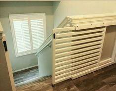 an empty room with white shutters on the wall and wood flooring in it