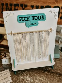 a sign that says pick your chain on the front and side of it with beads hanging from it