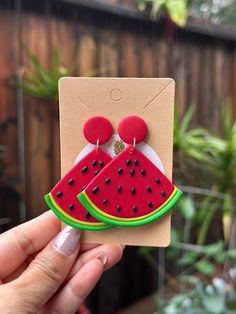 a person holding up a piece of paper with a watermelon design on it