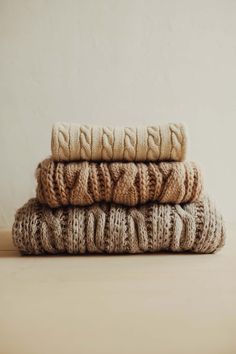 three knitted blankets stacked on top of each other