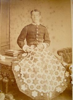 an old photo of a woman sitting on a chair with a crocheted skirt