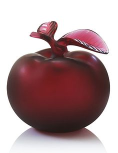 a red glass apple with a leaf on top